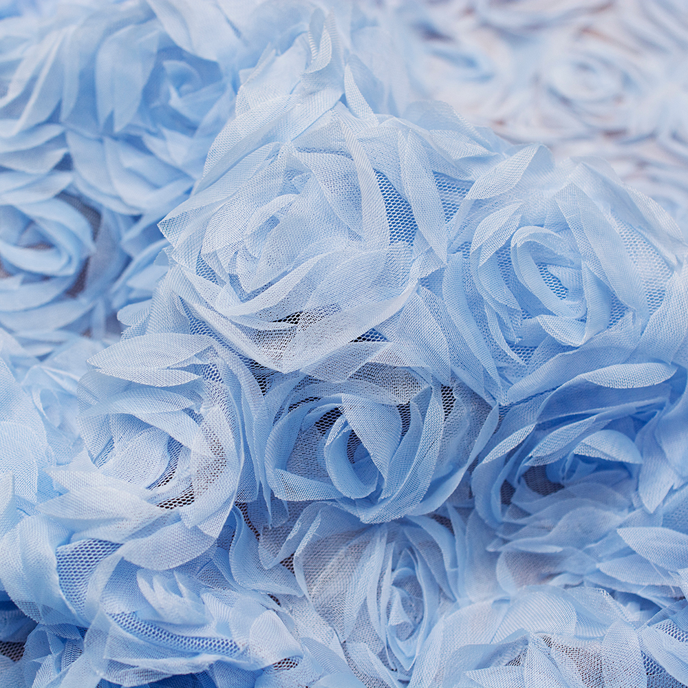 Haftowany tiul z dużym motywem niebieskich różyczek to subtelna i wyjątkowo lekka tkanina, która zachwyca swoją finezją.