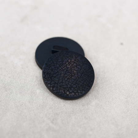 Plastikowy guzik na stopce, o średnicy 2,5 cm.