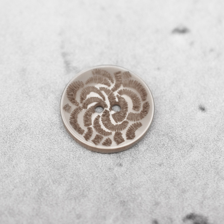 Plastikowy guzik przyszywany na dwie dziurki, o średnicy 2,3 cm.