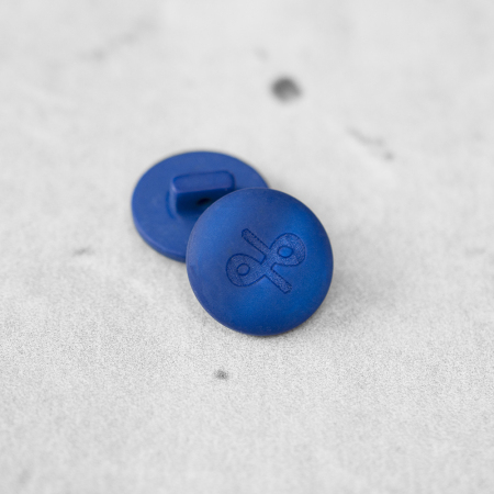 Plastikowy guzik na stopce, o średnicy 1,8 cm.