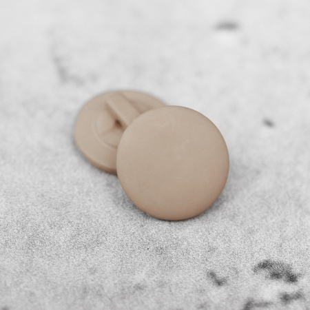 Plastikowy guzik na stopce, o średnicy 1,8 cm.