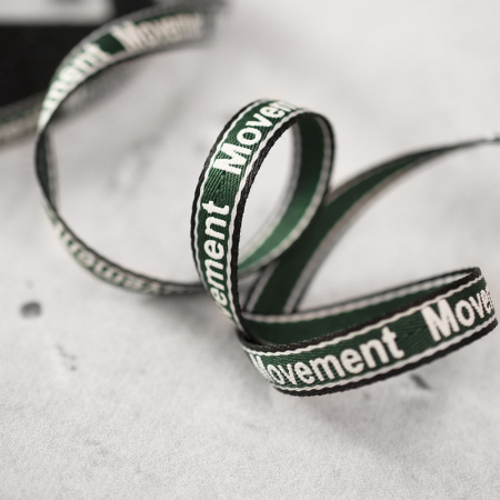 Dekoracyjna taśma w kolorze zielonym, ozdobiona dodatkowo białym napisem 