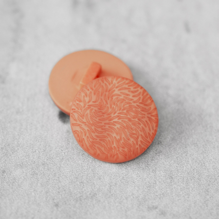 Plastikowy guzik na stopce, o średnicy 2,3 cm.