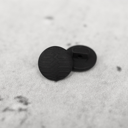 Plastikowy guzik na stopce, o średnicy 1,5 cm.