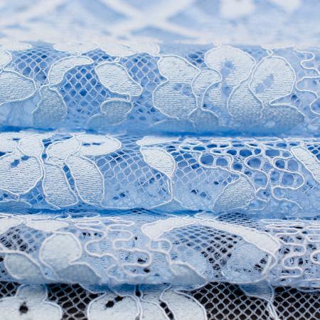 Koronka Roma to wysokiej jakości tkanina o eleganckim charakterze, wykonana z dodatkiem naturalnych włókien, które podnoszą jej komfort noszenia.